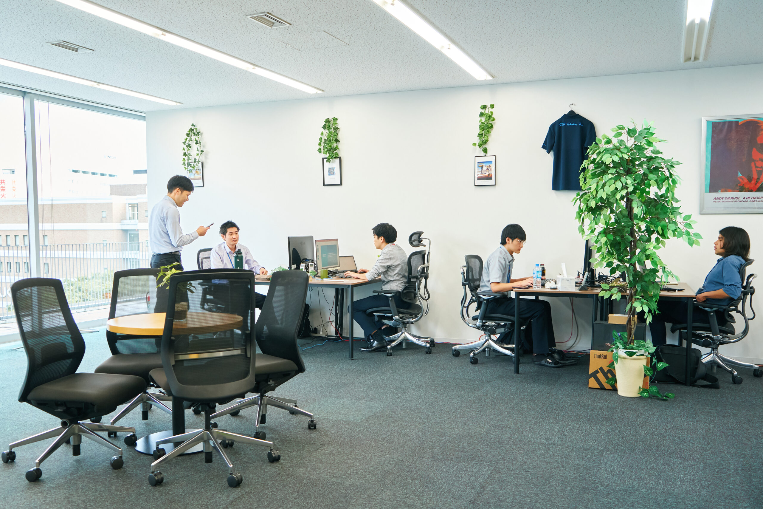 株式会社SRA東北のオフィスで社員5名が業務をしている風景