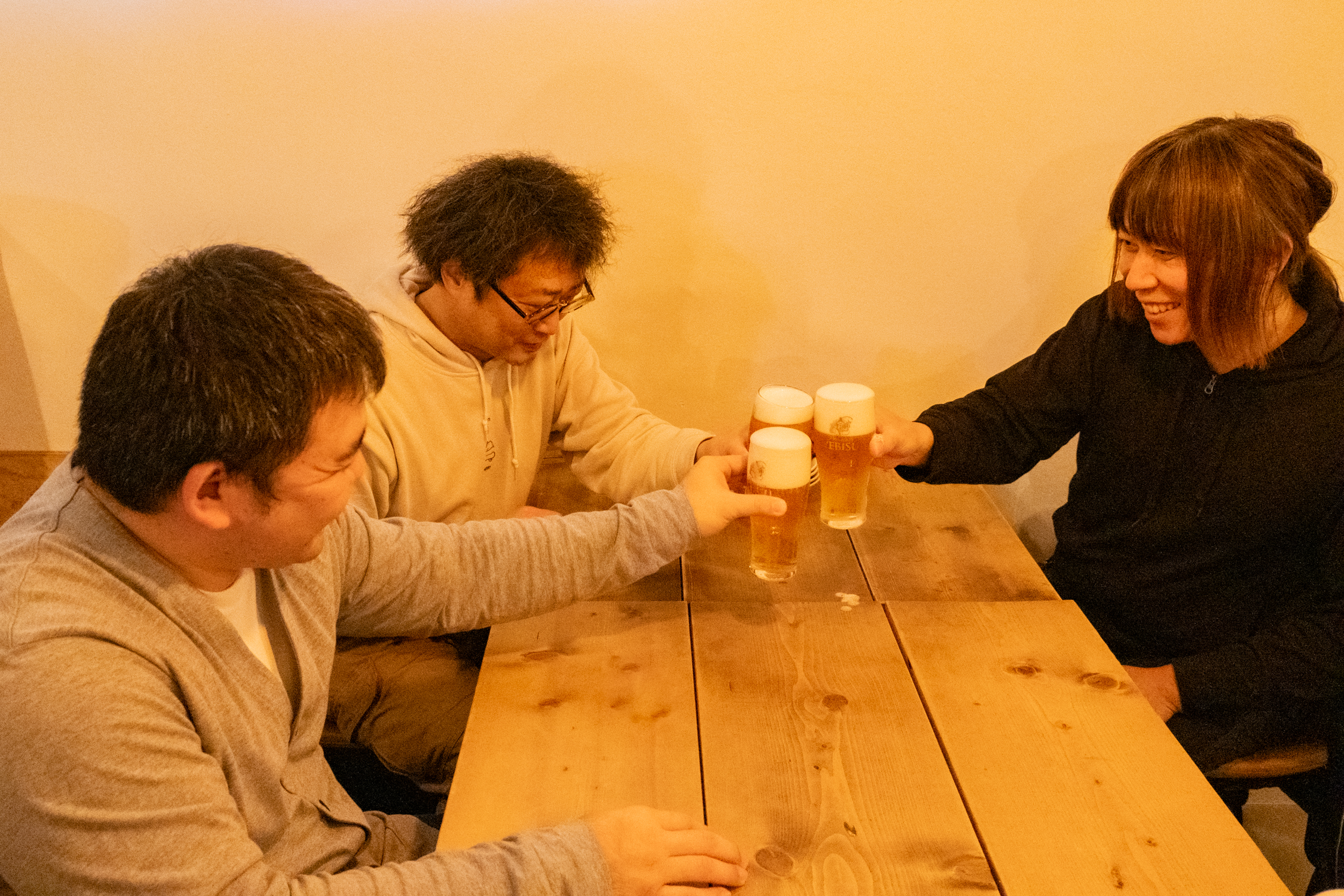 グラスのビールで乾杯をする萩野輝さん、齋藤昌秀さん、澤田周さん