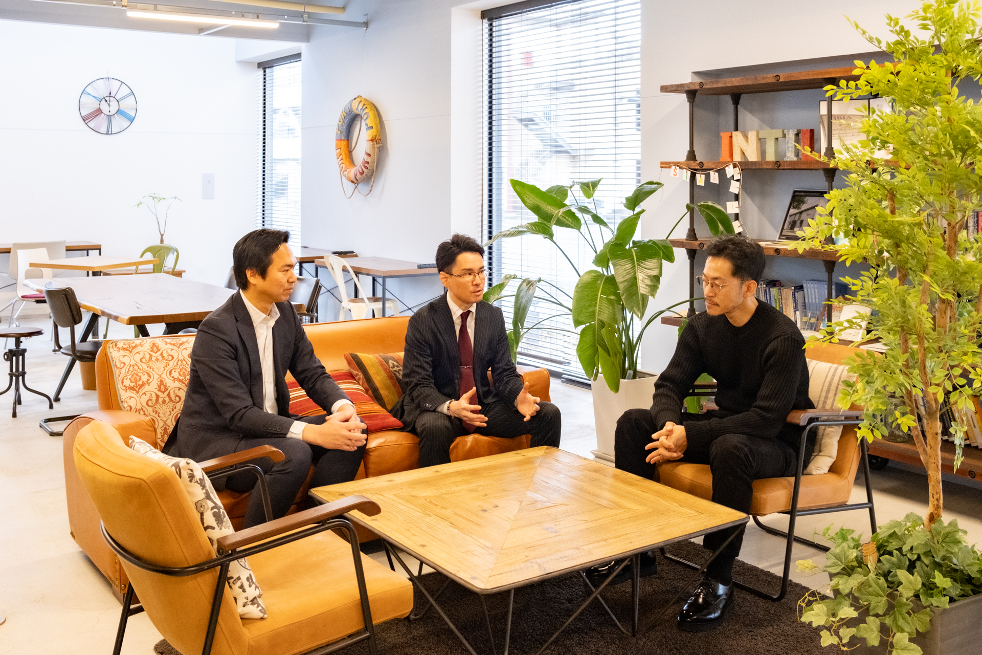 三人が座談会をしている様子、竹川さんと久本さんが横に並んで座っており、角の席に氏家さんが座っている